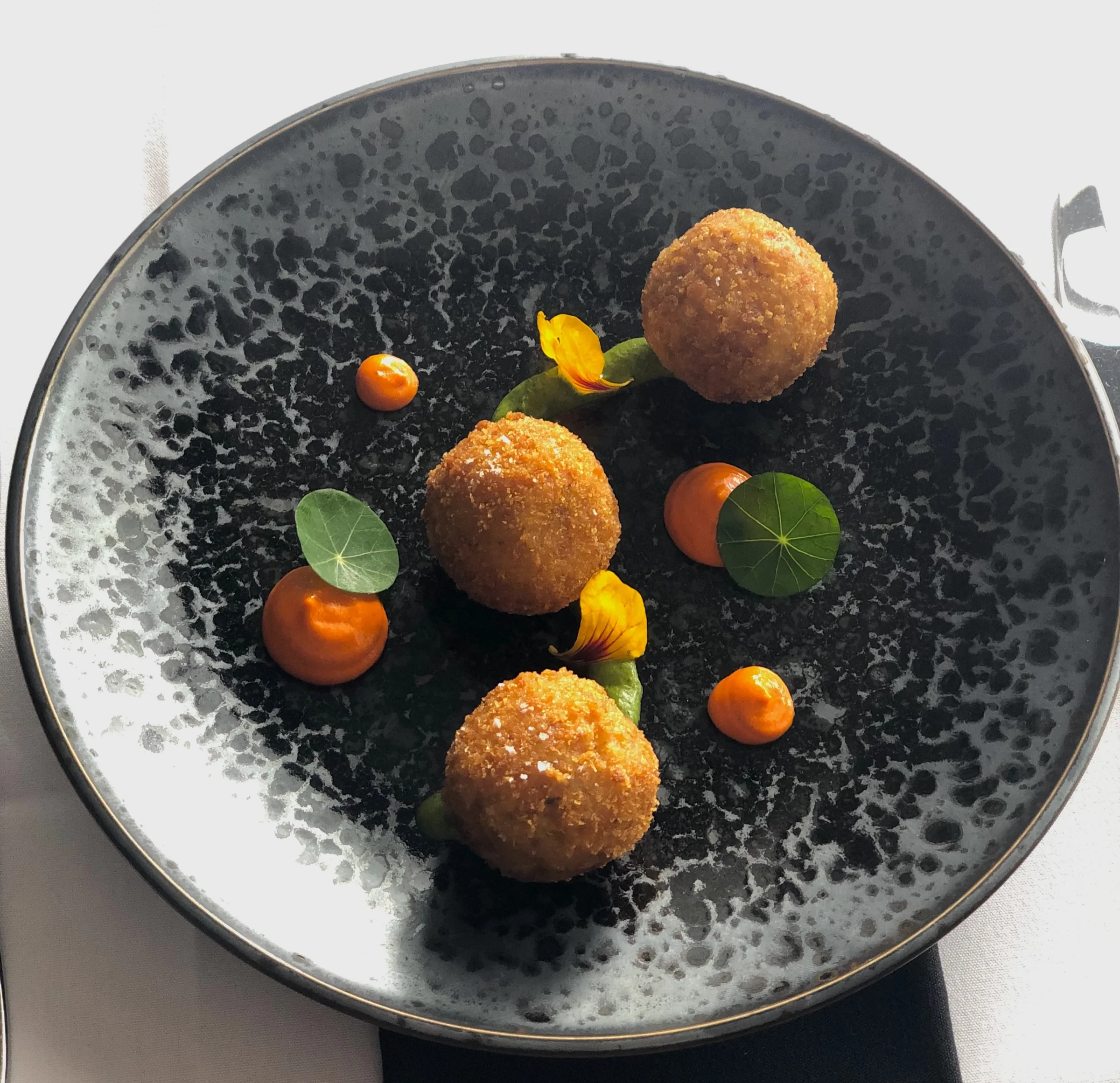 Leek and black truffle arancini, romesco, rocket and nasturtium by Sicily Chef
